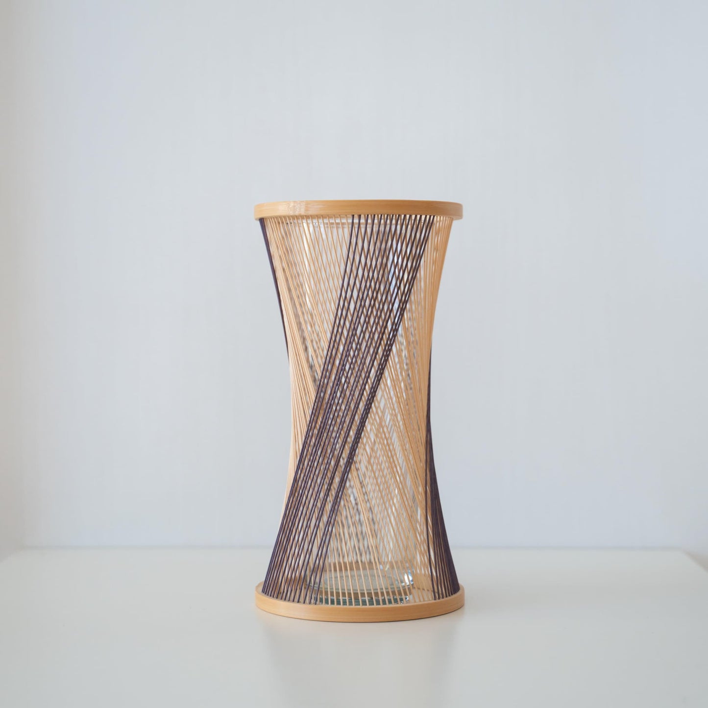Handcrafted Japanese bamboo Ikebana vase, meticulously crafted by skilled artisans using traditional bamboo weaving techniques, showcasing the natural beauty and elegance of bamboo.