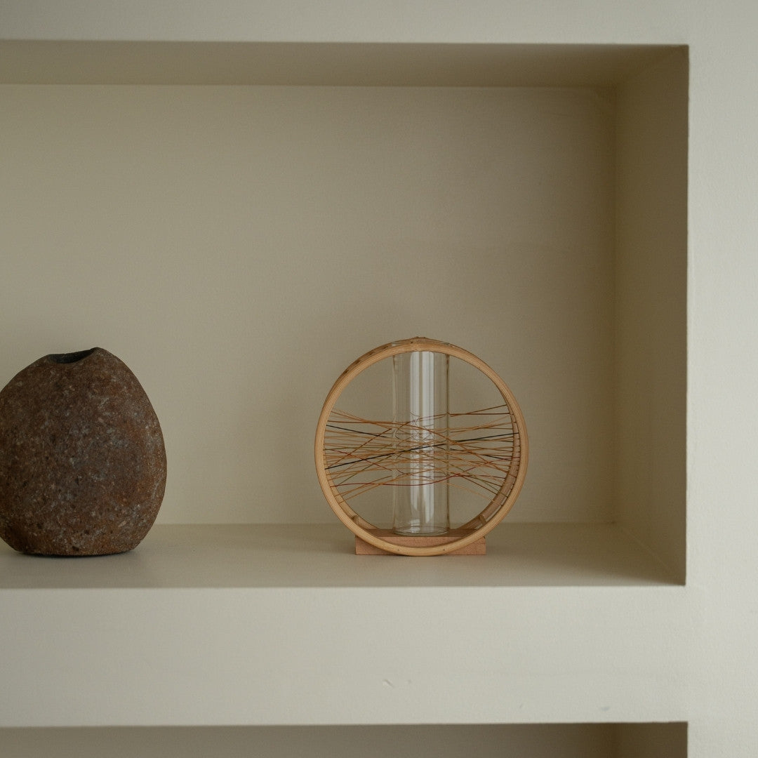 Japansk bambus blomstervase "Flydende Vind" på en hvid hylde - Japandi-stil ikebana blomstervase med wabi-sabi æstetik