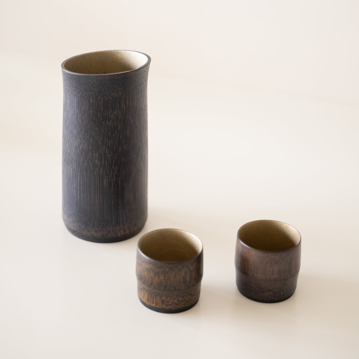 Japanisches Bambus-Sake-Set Schwarz vor weißem Hintergrund