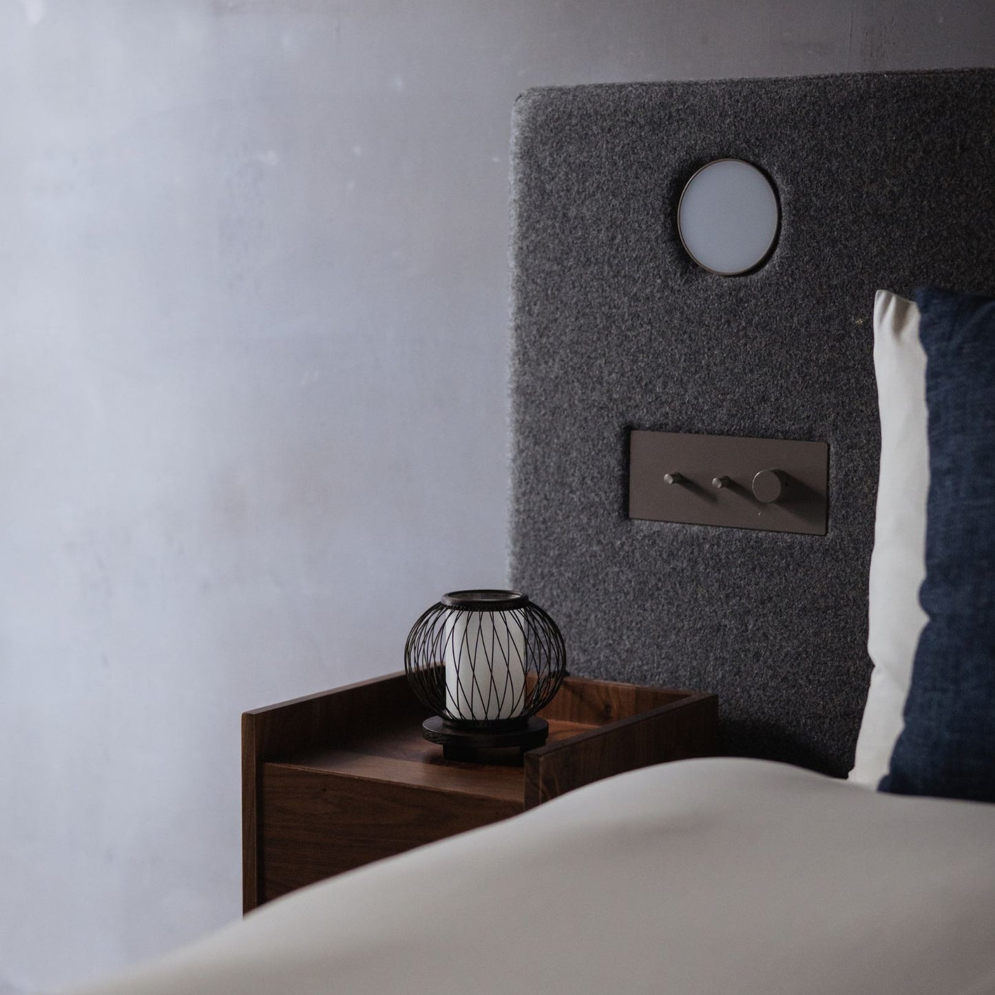 Een Japanse bamboe tafellamp geplaatst op een nachtkastje in een slaapkamer in Japandi-stijl.
