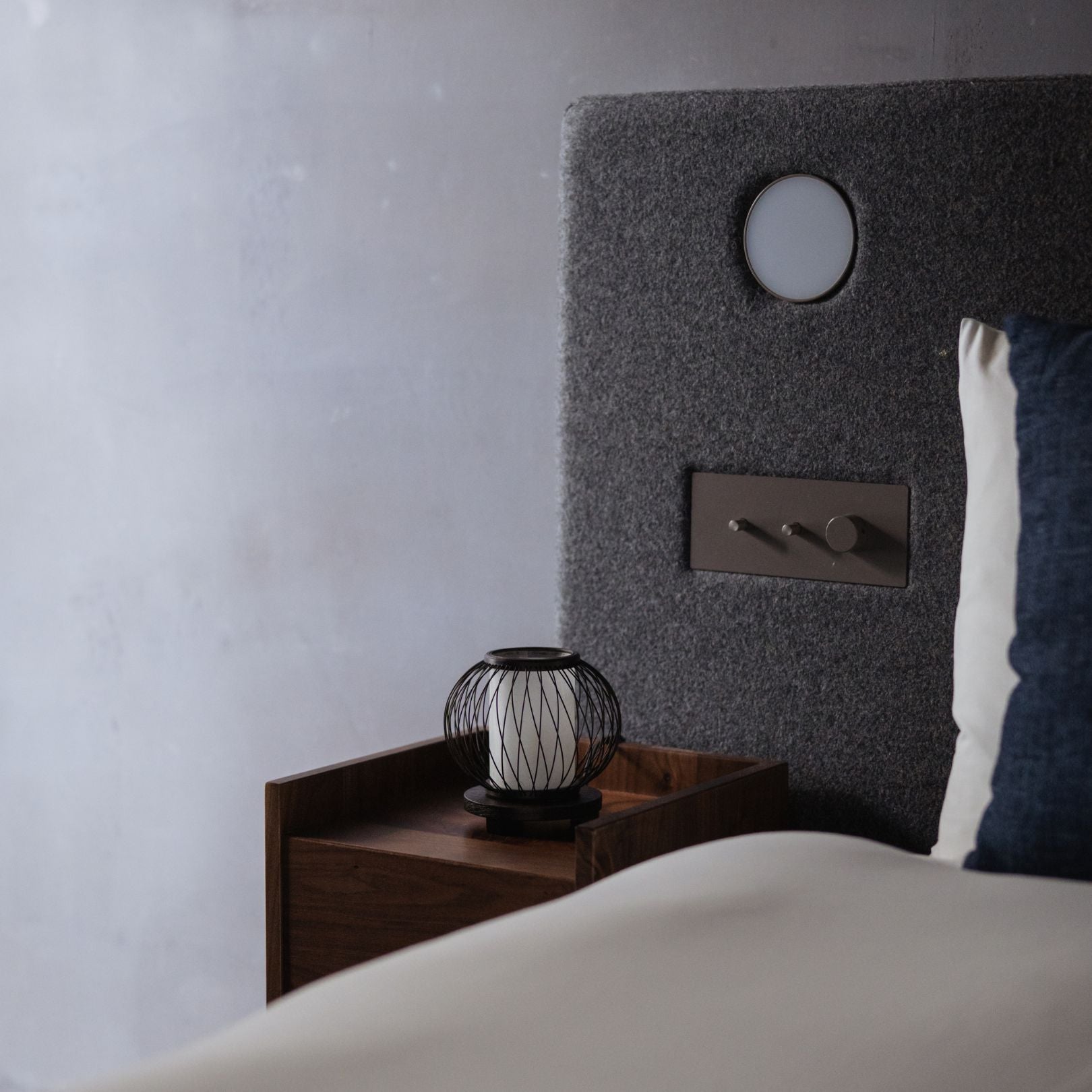 Een Japanse bamboe tafellamp geplaatst op een nachtkastje in een slaapkamer in Japandi-stijl.