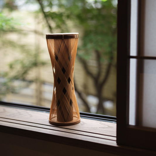 Handcrafted Japanese bamboo Ikebana vase, meticulously crafted by skilled artisans using traditional bamboo weaving techniques, showcasing the natural beauty and elegance of bamboo.