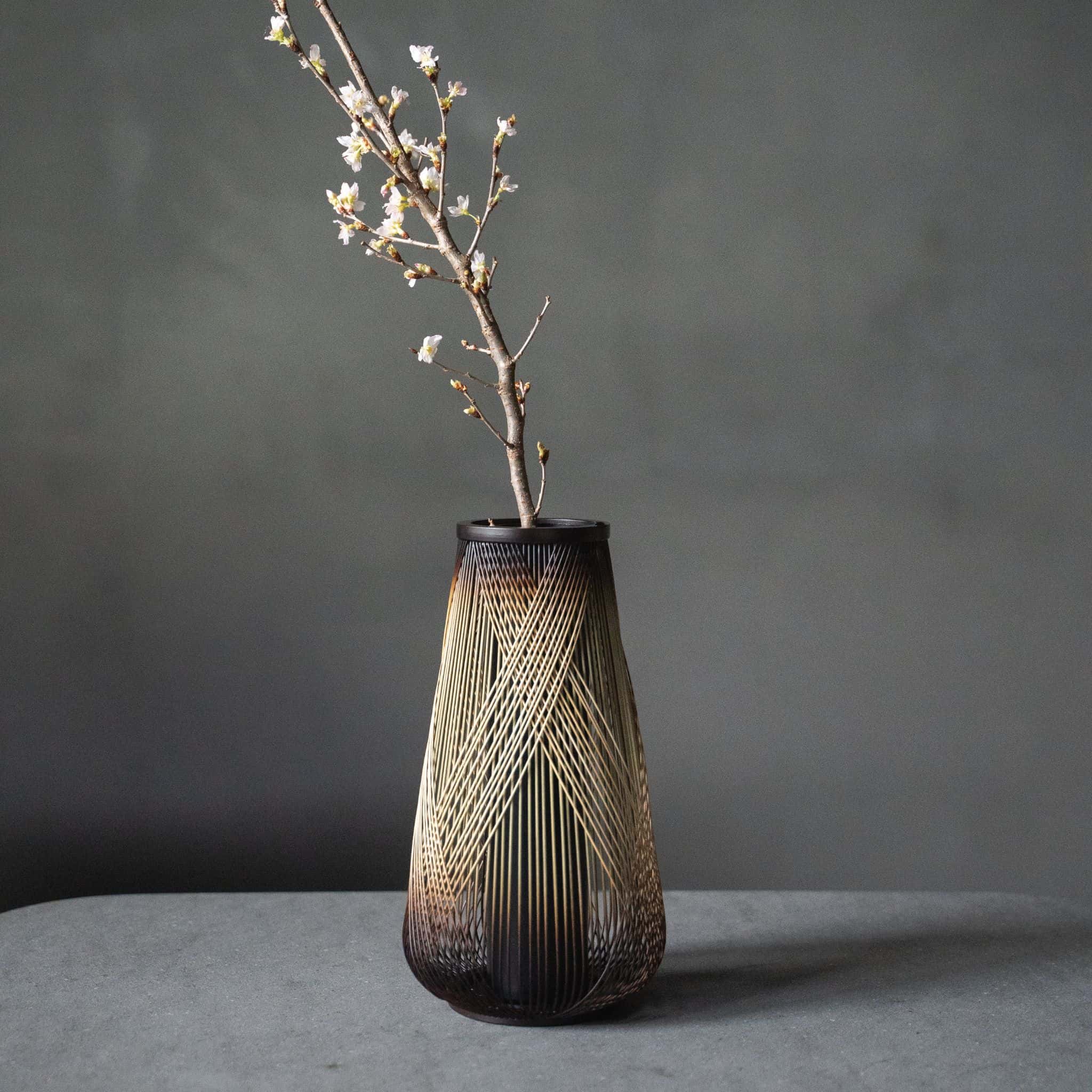 Japansk bambusvase med titlen "Rising Dragon" udstillet på et gråt hotelbord.