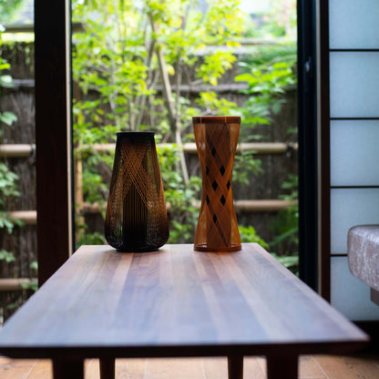 Zwei japanische Bambusvasen auf einem Holztisch in einem Japandi-Wohnzimmer. 