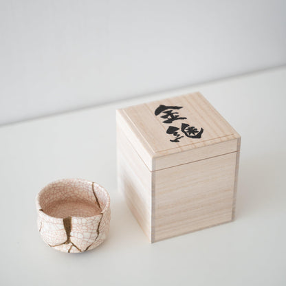 Gavesæt med en hvid te-skål repareret med Kintsugi, en traditionel japansk teknik, og en paulownia-trækasse.