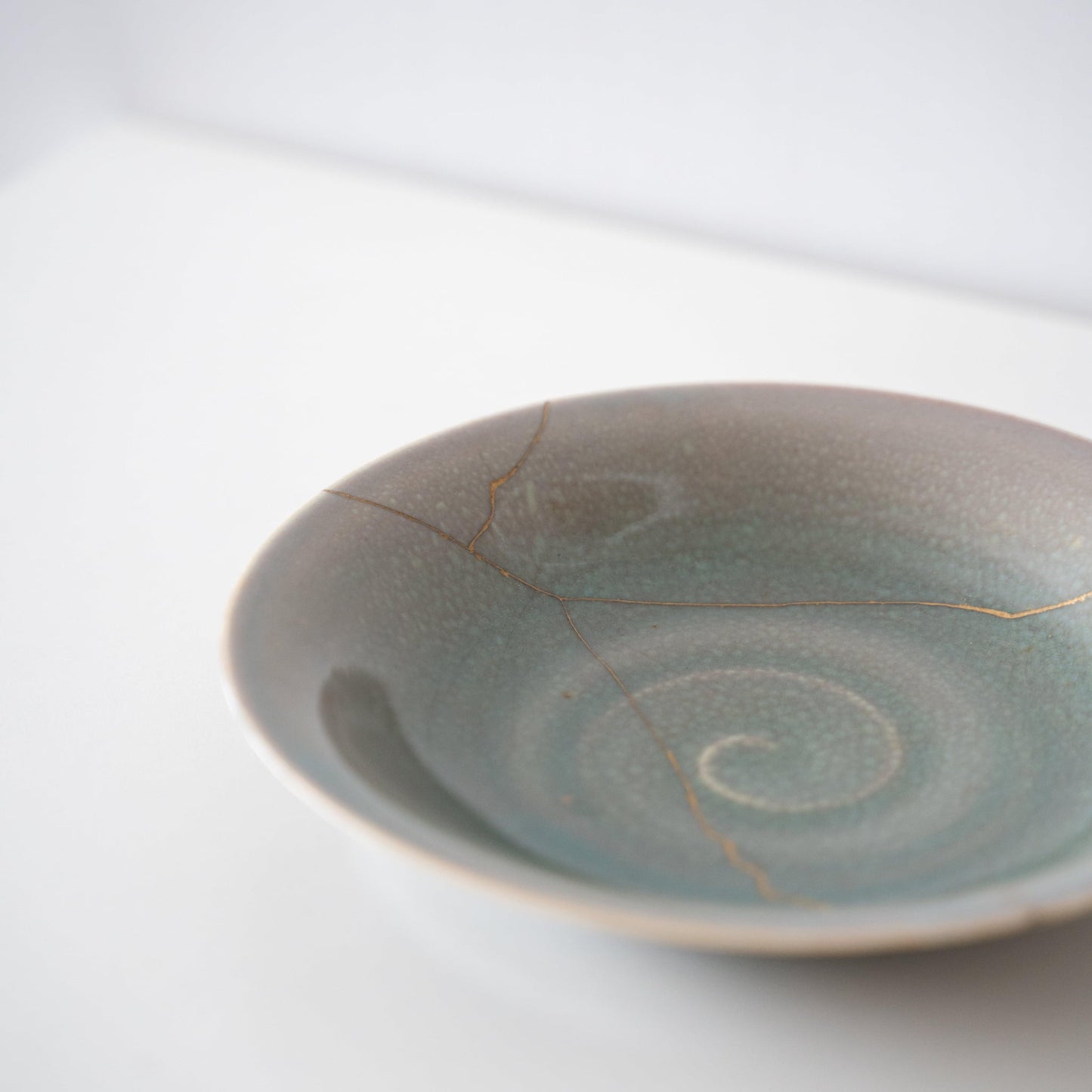 Lys grøn skål repareret med Kintsugi, en traditionel japansk teknik.
