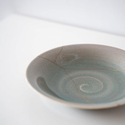 Lys grøn skål repareret med Kintsugi, en traditionel japansk teknik.
