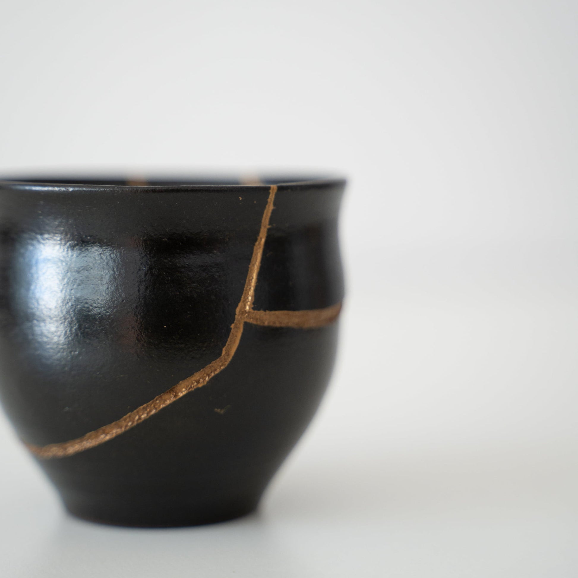 Japansk sakekop repareret med Kintsugi, en traditionel japansk teknik, med sort lak 