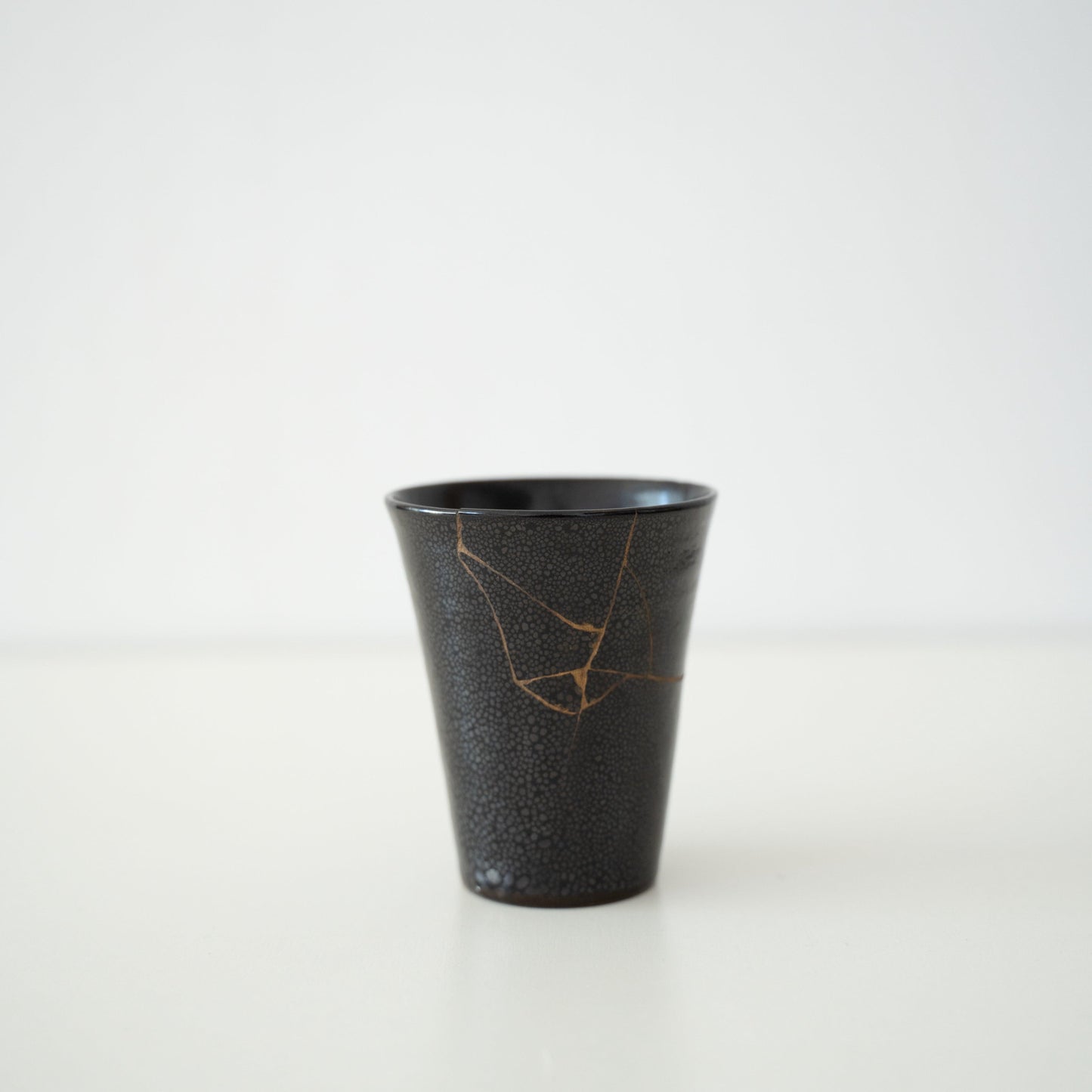 Japansk kop repareret med Kintsugi, en traditionel japansk teknik, med sort lak og navnet "Shikkoku Rai" (Kulsort Torden).