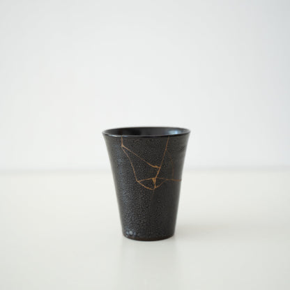Japansk kop repareret med Kintsugi, en traditionel japansk teknik, med sort lak og navnet "Shikkoku Rai" (Kulsort Torden).