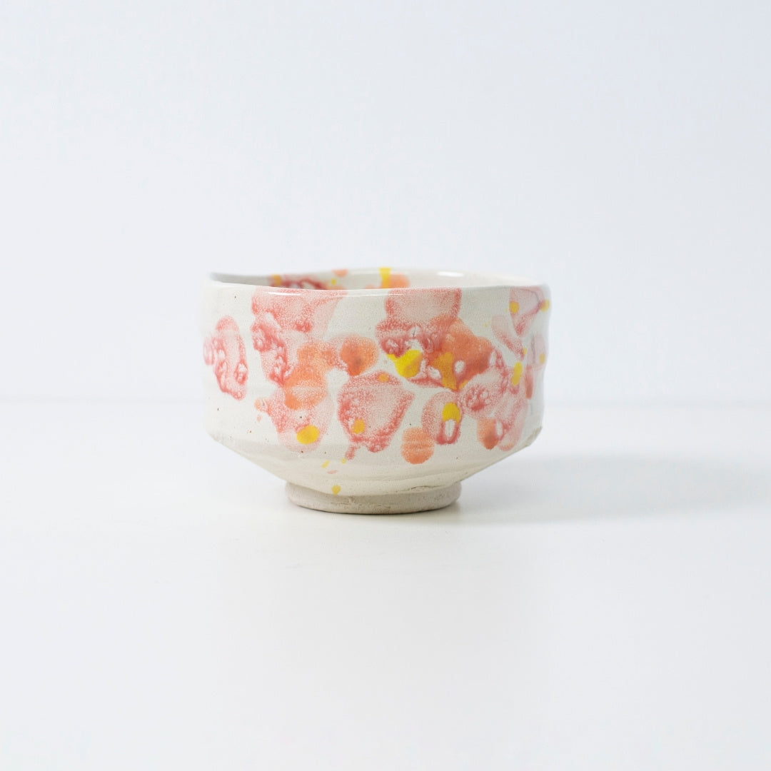 Håndlavet japansk matcha-skål "Blomst" med rød-gul glasur, perfekt til te eller dekoration.