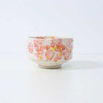 Håndlavet japansk matcha-skål "Blomst" med rød-gul glasur, perfekt til te eller dekoration.