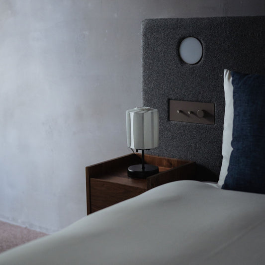 A Japanese Origami Paper Lamp "Flower of Light" on a bedside table. 