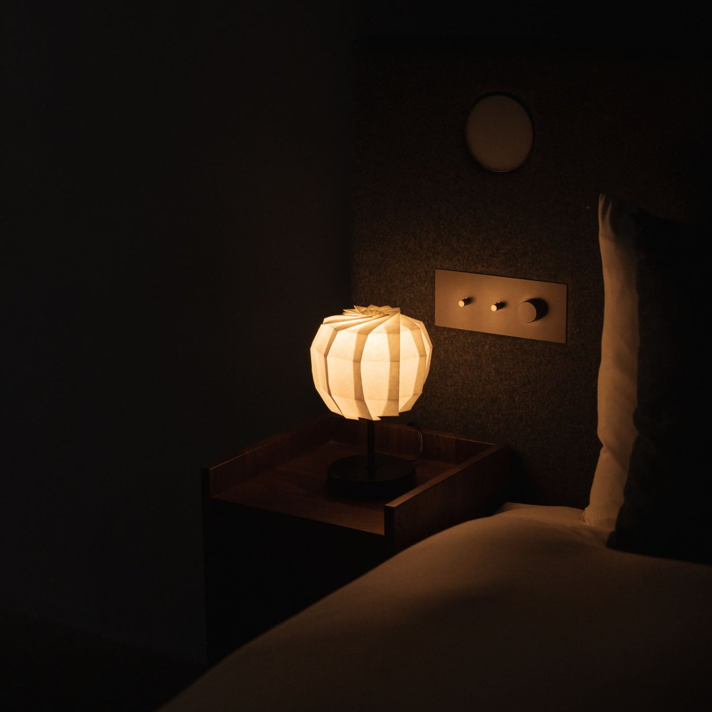 Japanse papieren tafellamp "Bloem van Licht maru met standaard" op een houten nachtkastje