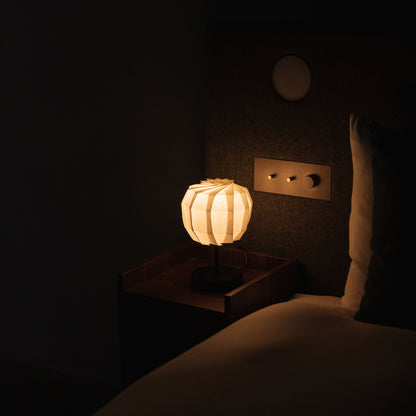 Japanse papieren tafellamp "Bloem van Licht maru met standaard" op een houten nachtkastje