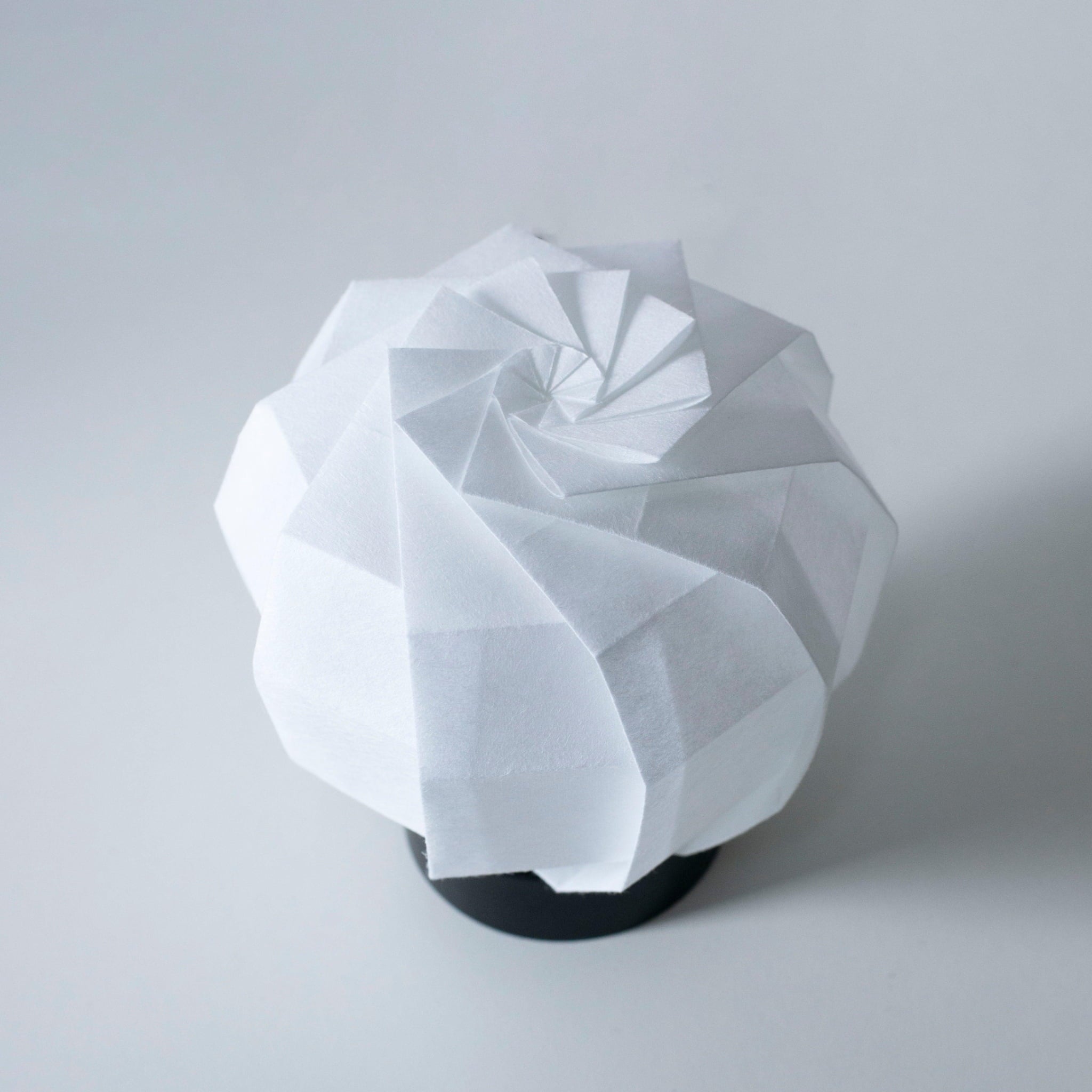 Frameloze Japanse papieren tafellamp, vervaardigd met traditionele Kyo-hyogu en origami-technieken, met een uniek origami-patroon.