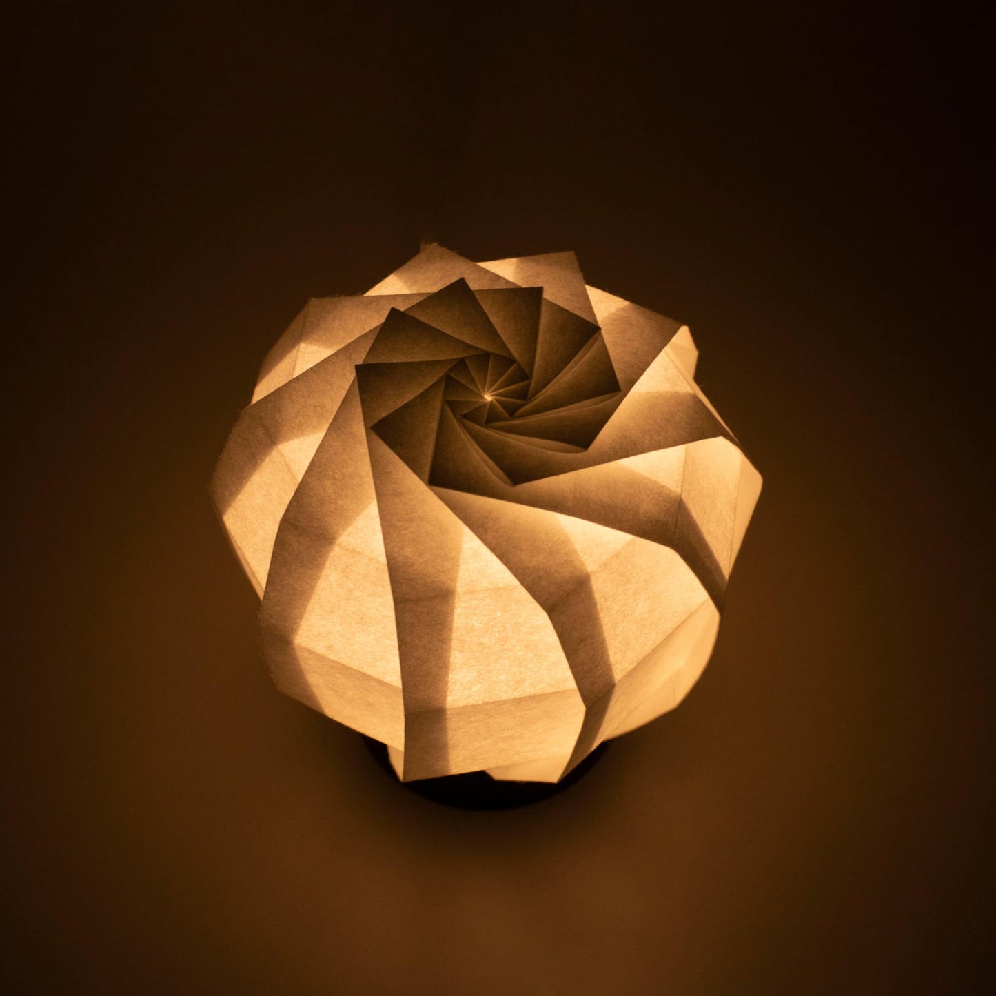 Frameloze Japanse tafellamp vervaardigd met traditionele Kyo-hyogu en origami-technieken, met een uniek verlicht origami-patroon.
