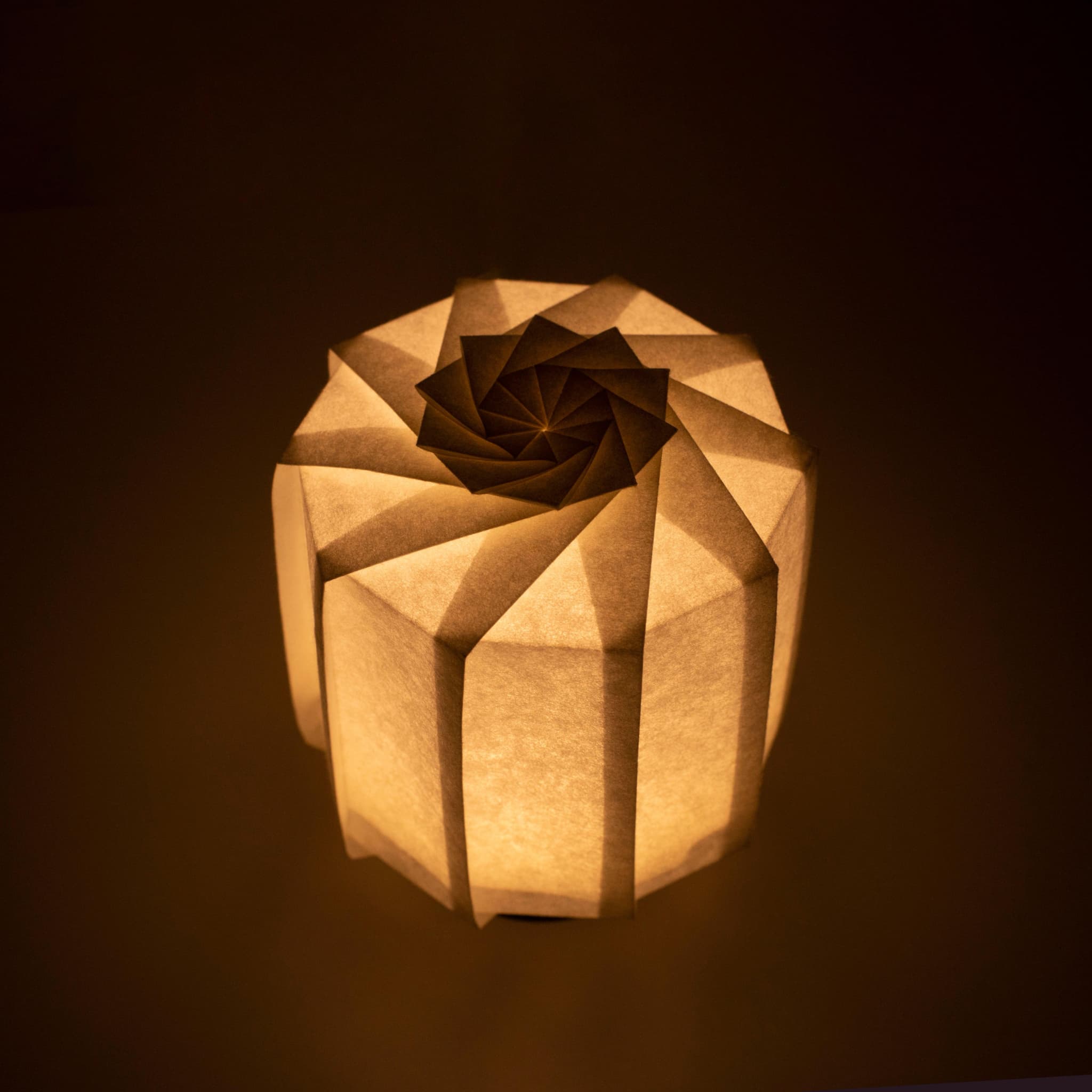 Frameloze Japanse tafellamp vervaardigd met traditionele Kyo-hyogu en origami-technieken, met een uniek verlicht origami-patroon.