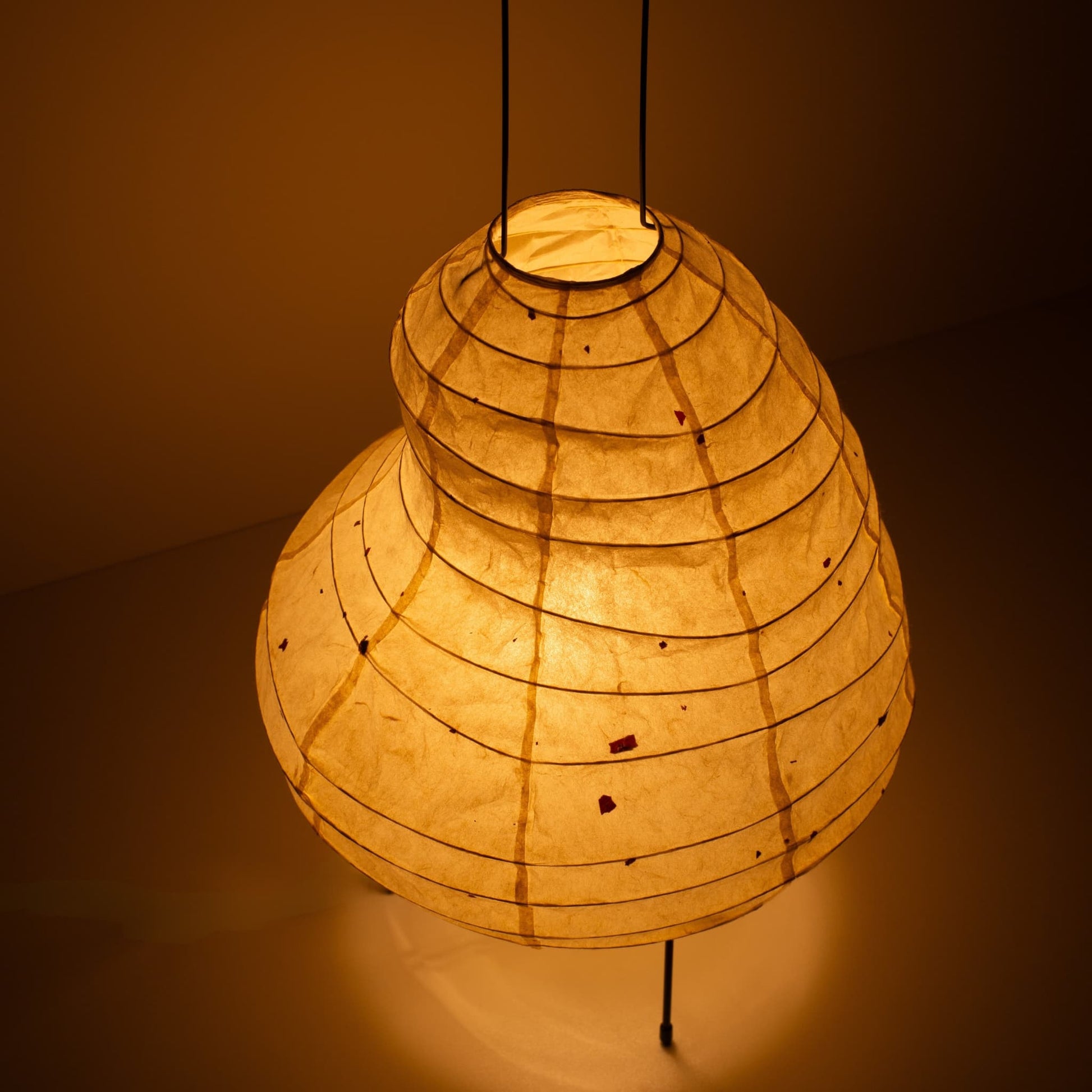 Gros plan d'une lampe sur pied unique en forme de haricot, fabriquée avec des techniques de lanternes de Gifu et du papier Mino washi.