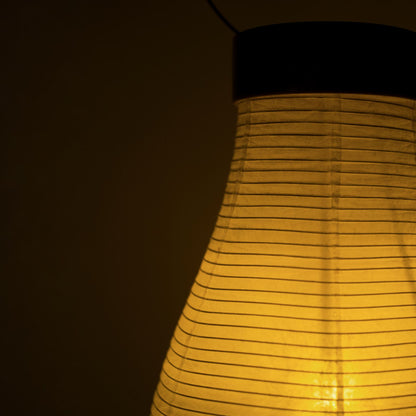 Een traditionele Japanse papieren lantaarn die warm licht werpt in een donkere kamer