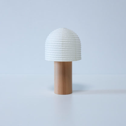 Japanese Paper Lantern with Bell-Shaped Top Against White Background	A portable Yame lantern with a bell-shaped top and wooden handle against a white background