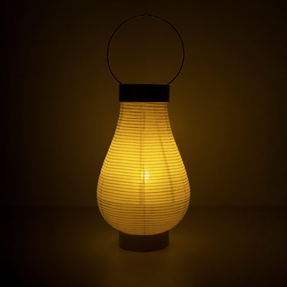 Een traditionele Japanse papieren lantaarnlamp die warm licht uitstraalt in een donkere kamer