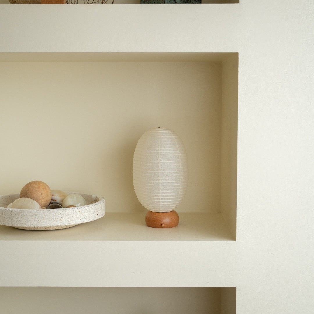 Japanese Paper Table Lamp "Dinosaur" on a white shelf in Japandi style room – Portable paper lamp for Japandi living room