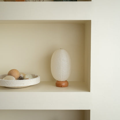 Japanese Paper Table Lamp "Dinosaur" on a white shelf in Japandi style room – Portable paper lamp for Japandi living room