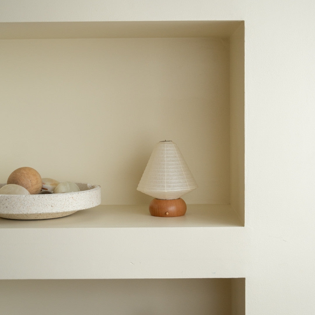 Japansk papir bordlampe "Mini Triangle" på en hvid hylde i et Japandi-stil rum – Wabi-Sabi natlampe til soveværelse