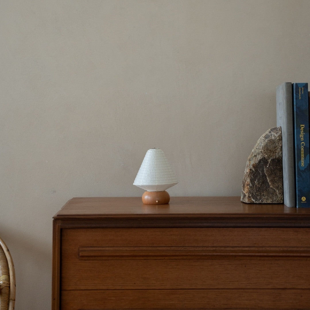 Japansk papir bordlampe "Mini Triangle" på træhylde i stue i Japandi-stil – Unik papir bordlampe