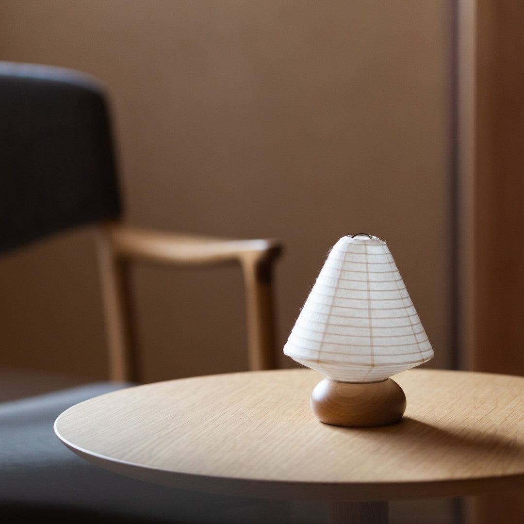 Japansk papir bordlampe "Mini Triangle" på et træbord i en stue