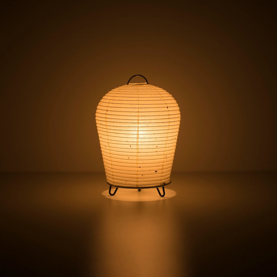 Japanse Papieren Tafellamp "PAPERSON 01" die een warme gloed afgeeft in een donkere kamer – Unieke Papieren Nachtkastlamp voor Japandi Slaapkamer