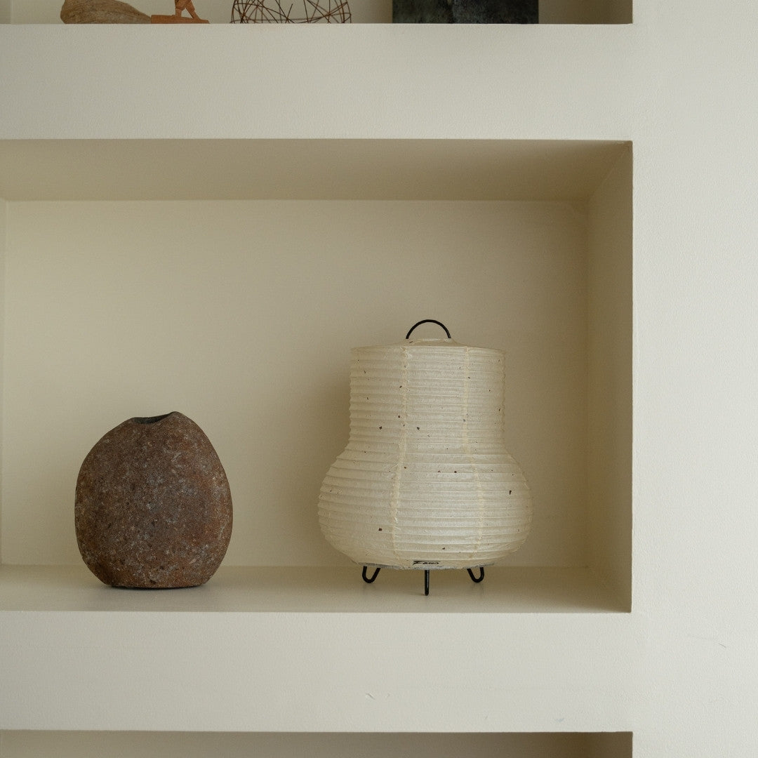 Japanse papieren tafellamp "PAPERSON 02" op een witte plank in een woonkamer in Japandi-stijl – papieren tafellamp voor Japandi-interieur