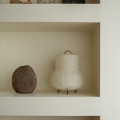 Japanse papieren tafellamp "PAPERSON 02" op een witte plank in een woonkamer in Japandi-stijl – papieren tafellamp voor Japandi-interieur