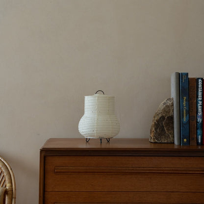 "Japans papieren tafellampje \"PAPERSON 02\" op een houten tafel in een Japandi woonkamer - Uniek nachtlampje voor Japandi interieur"