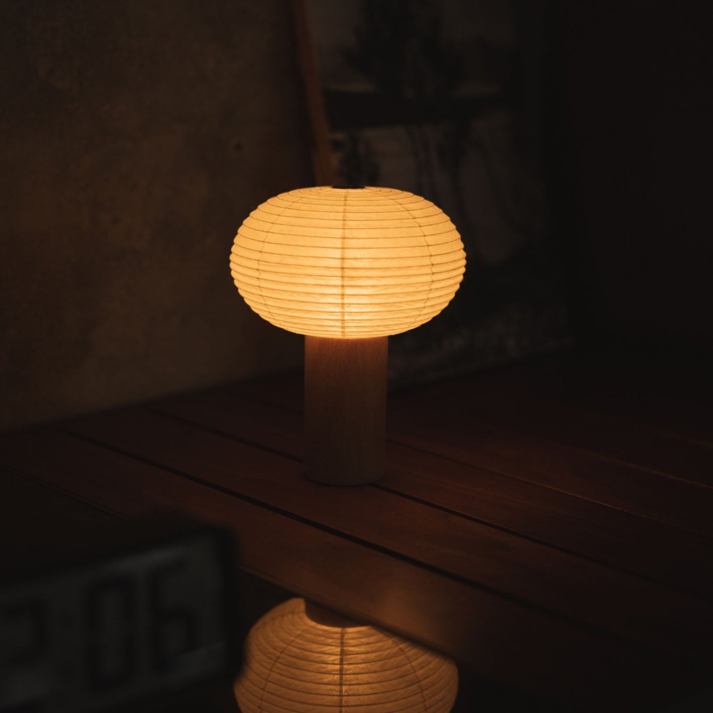 Japanische Papier-Tischlampe "TORCHIN OVAL" auf einem Konsolentisch im Wohnzimmer