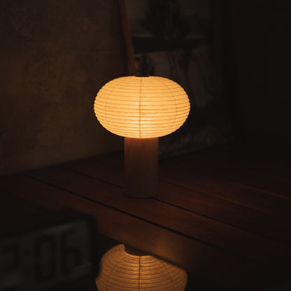 Japanische Papier-Tischlampe "TORCHIN OVAL" auf einem Konsolentisch im Wohnzimmer