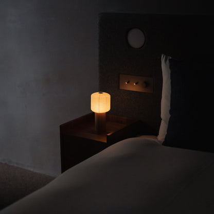 "Eine japanische Papier-Touch-Lampe „TORCHIN SQUARE“ auf einem Nachttisch." 