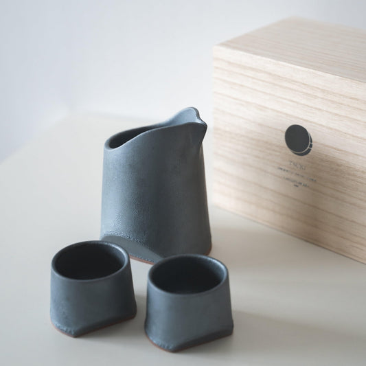 Gift set of iron-colored sake pitcher and two cups, crafted using traditional Japanese roof tile techniques, presented in a paulownia wood box.