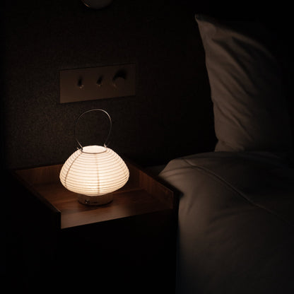 Japanese table lamp on a bedside table in a Japanese bedroom. 