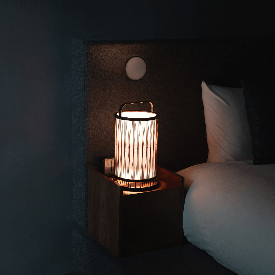"Traditionelle japanische Bambuslampe, gefertigt mit 800 Jahre alten Techniken aus Shizuoka, steht auf einem Nachttisch."