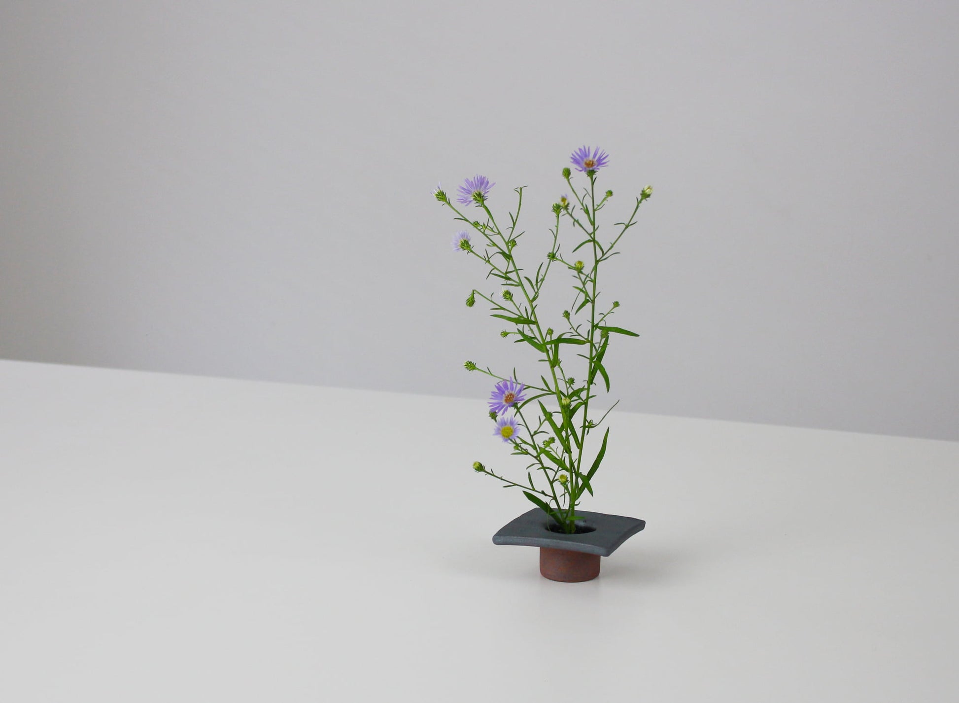 japansk jernfarvet ikebana-vase på et hvidt bord. 