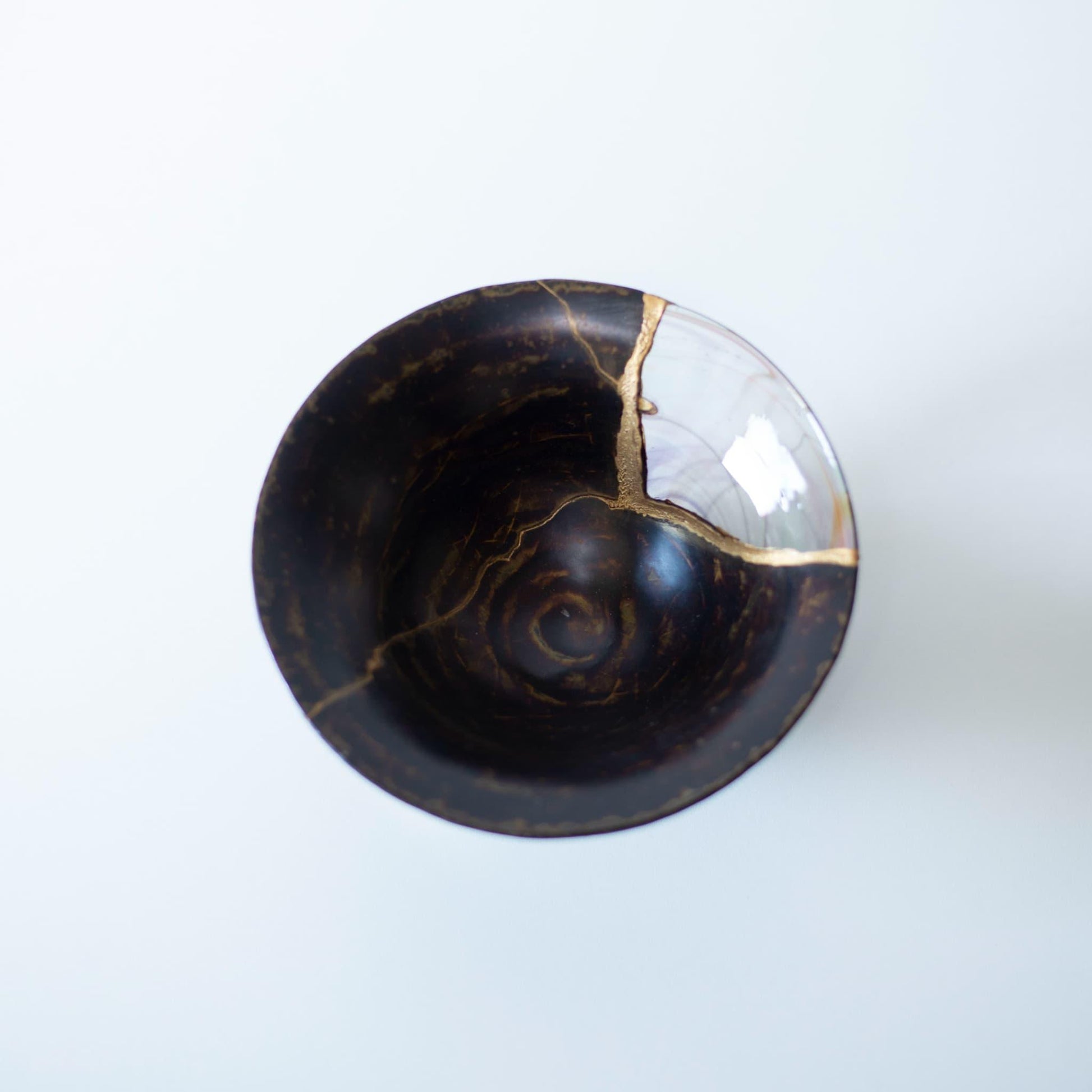 skål repareret ved hjælp af den udfordrende kintsugi-teknik, med en smuk fusion af kirsebærblomstfarvet keramik og lyseblåt glas.