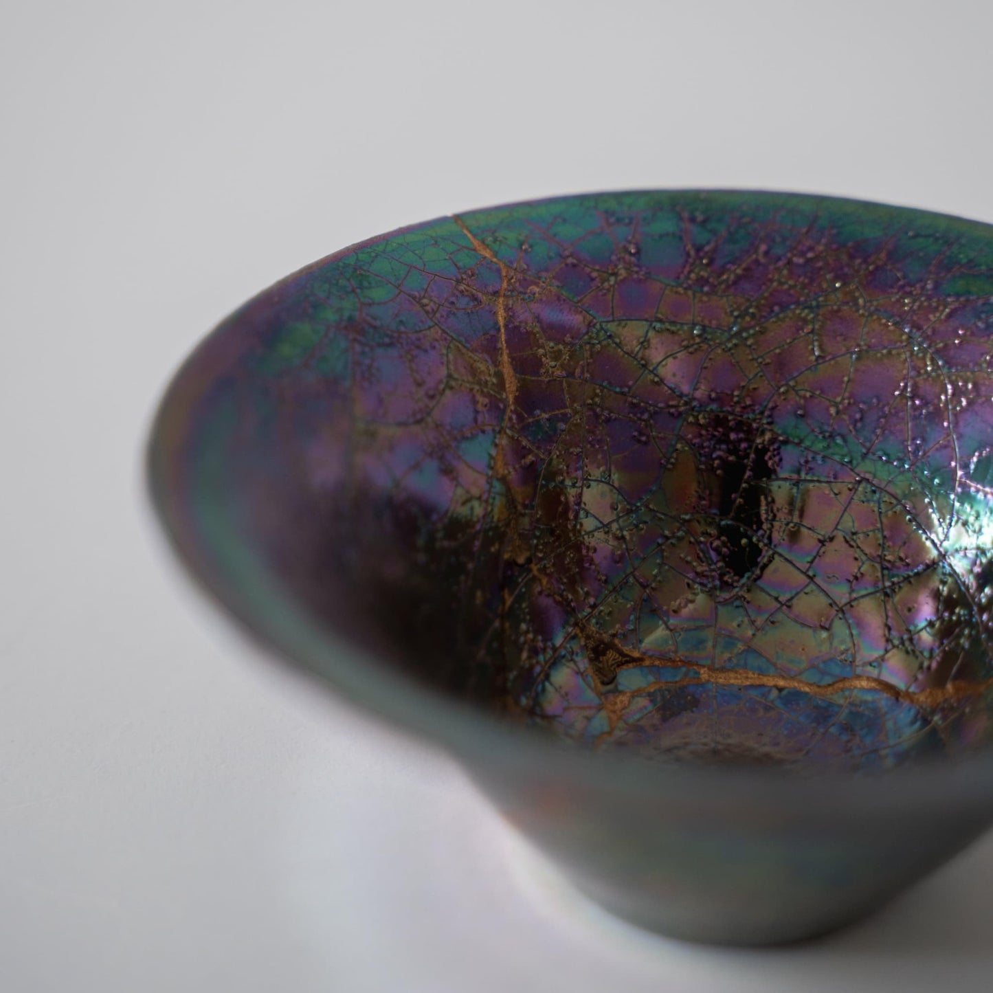 "Nahaufnahme der Seite der Kintsugi-Schale „Regenbogen-Glanz“, die die kunstvollen Kintsugi-Reparaturen hervorhebt"