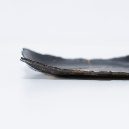 "Close-up van het zijaanzicht van Kintsugi-bord 'Tenmoku' Zwart 01, met nadruk op de textuur."