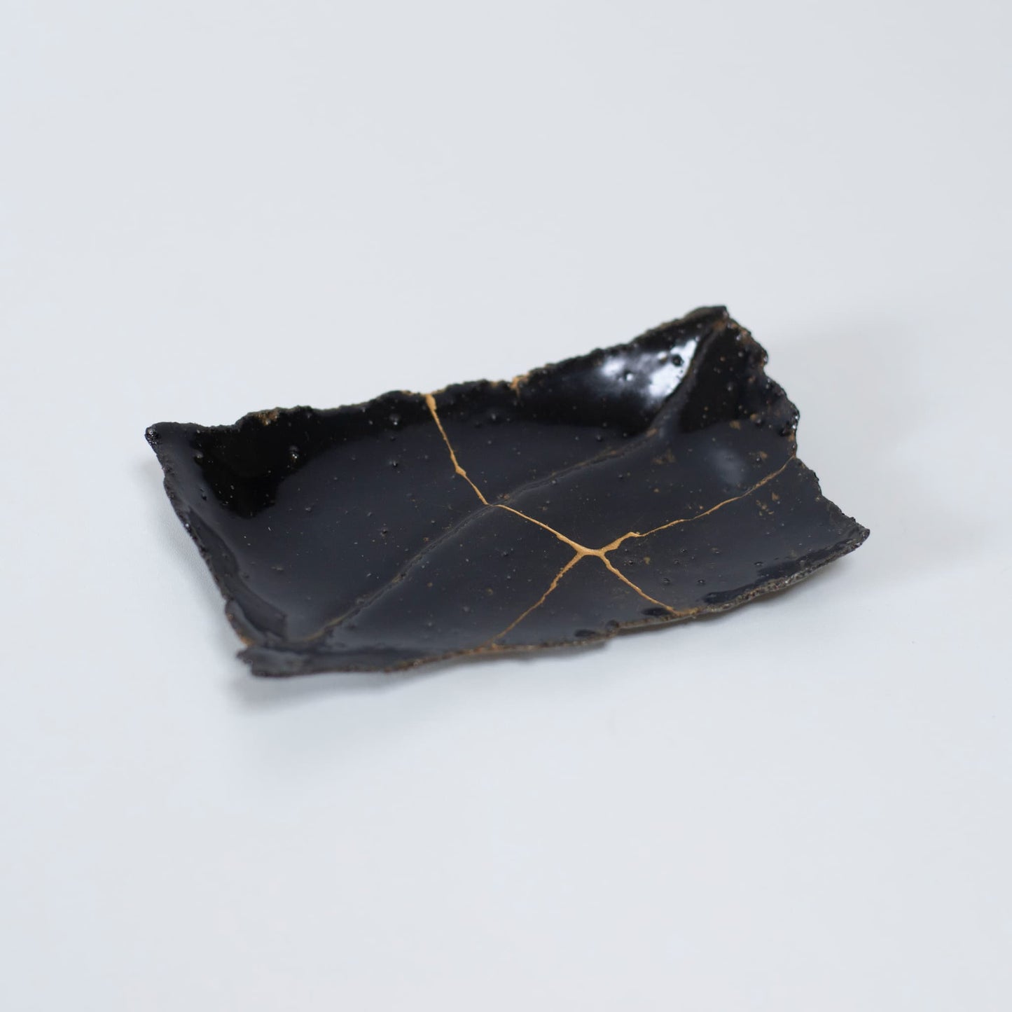 "Bovenaanzicht van Kintsugi-bord 'Tenmoku' Zwart 01, met een weergave van het elegante ontwerp"