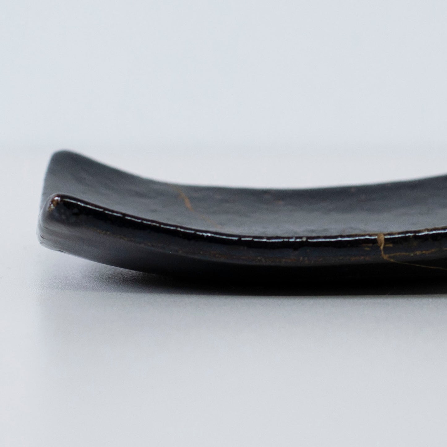 Nahaufnahme des Seitenprofils der Kintsugi Square Plate "Jet Black Lighting" 05, die die Textur hervorhebt.