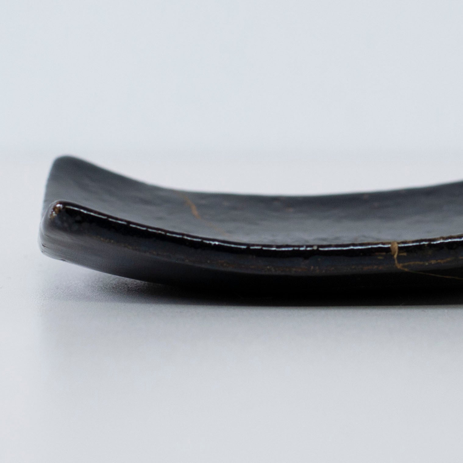 Nahaufnahme des Seitenprofils der Kintsugi Square Plate "Jet Black Lighting" 05, die die Textur hervorhebt.