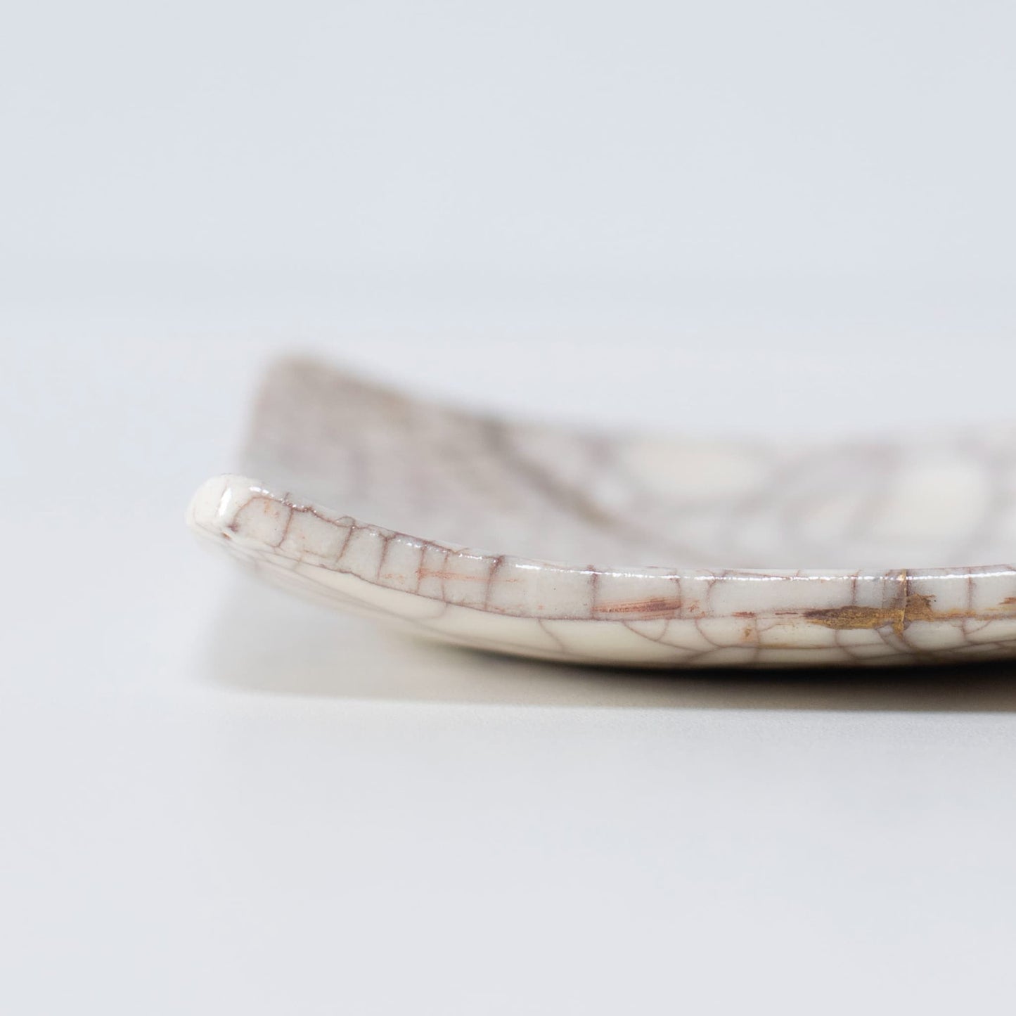Tæt på sideprofilen af Kintsugi Square Plate "Vermilion Crackle" 01, der fremhæver teksturen.