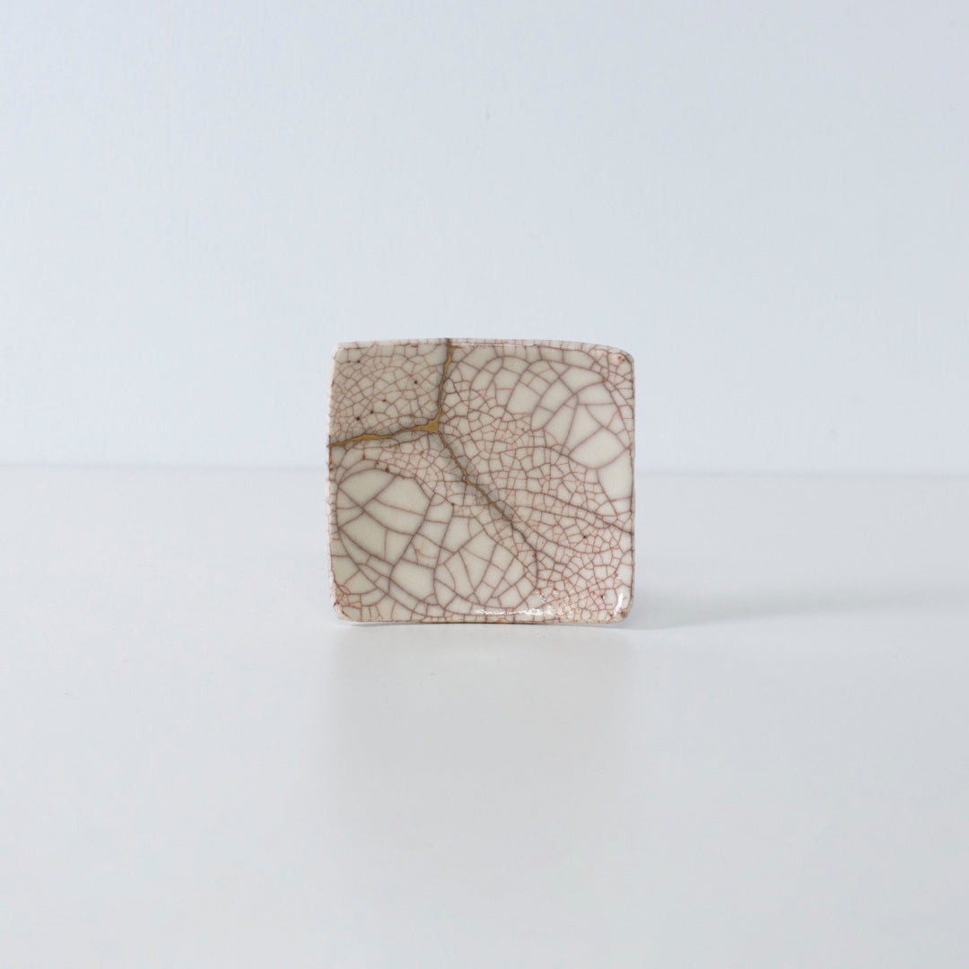 Zijaanzicht van Kintsugi vierkant bord "Vermilion Crackle" 06 tegen een witte achtergrond